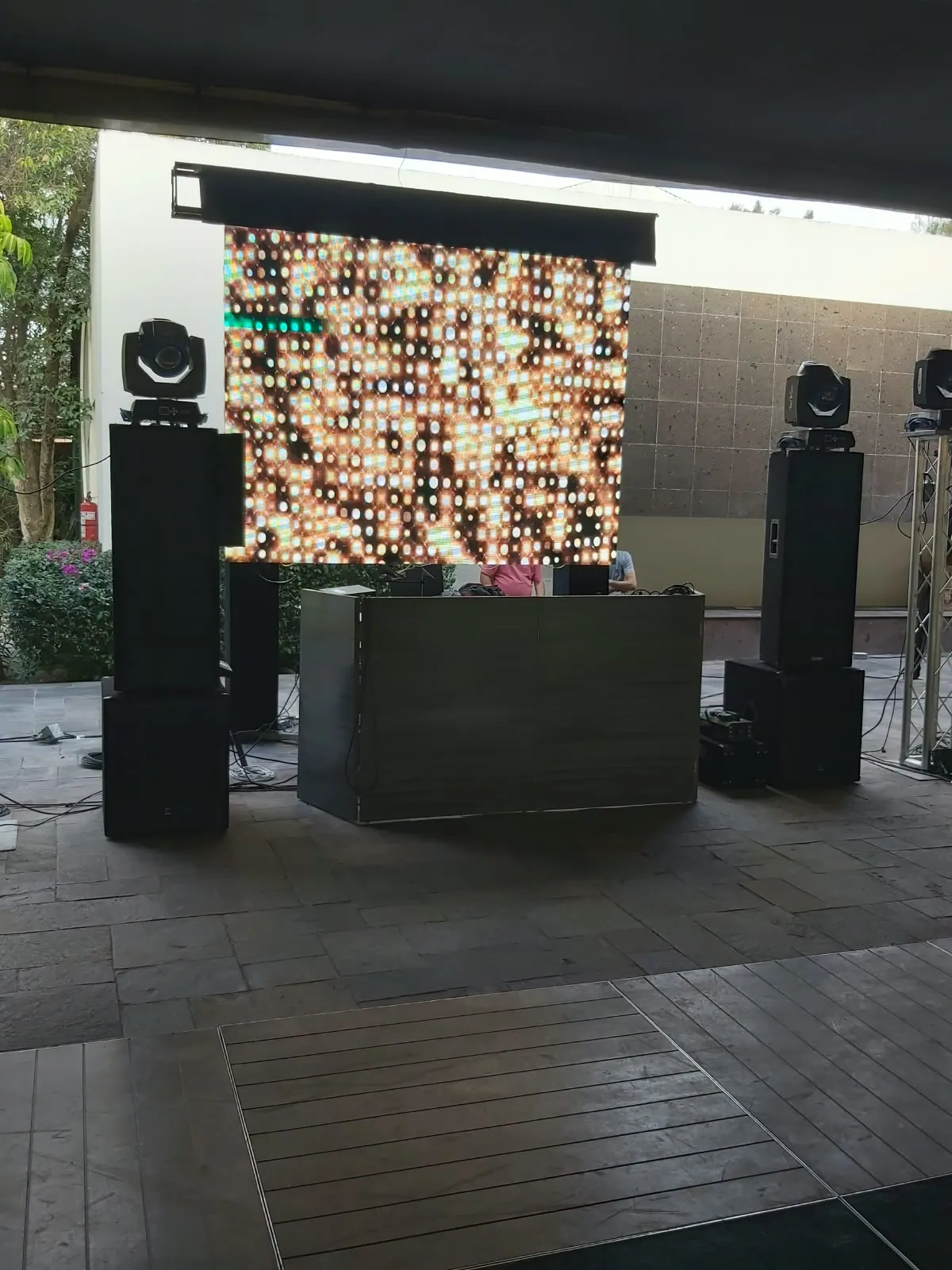 Cabina de DJ con bocinas, luces robóticas y muro LED