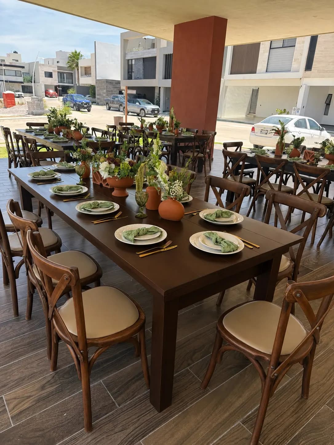 Mesa larga de madera con sillas crossback y centros de flores