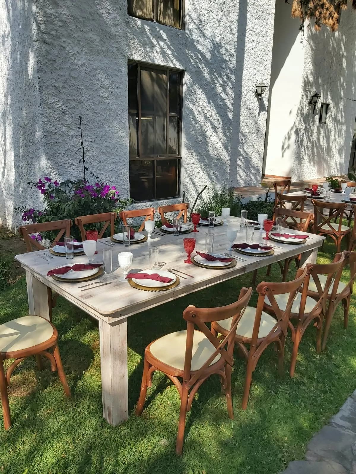 Mesa montada en un jardín con sillas crossback