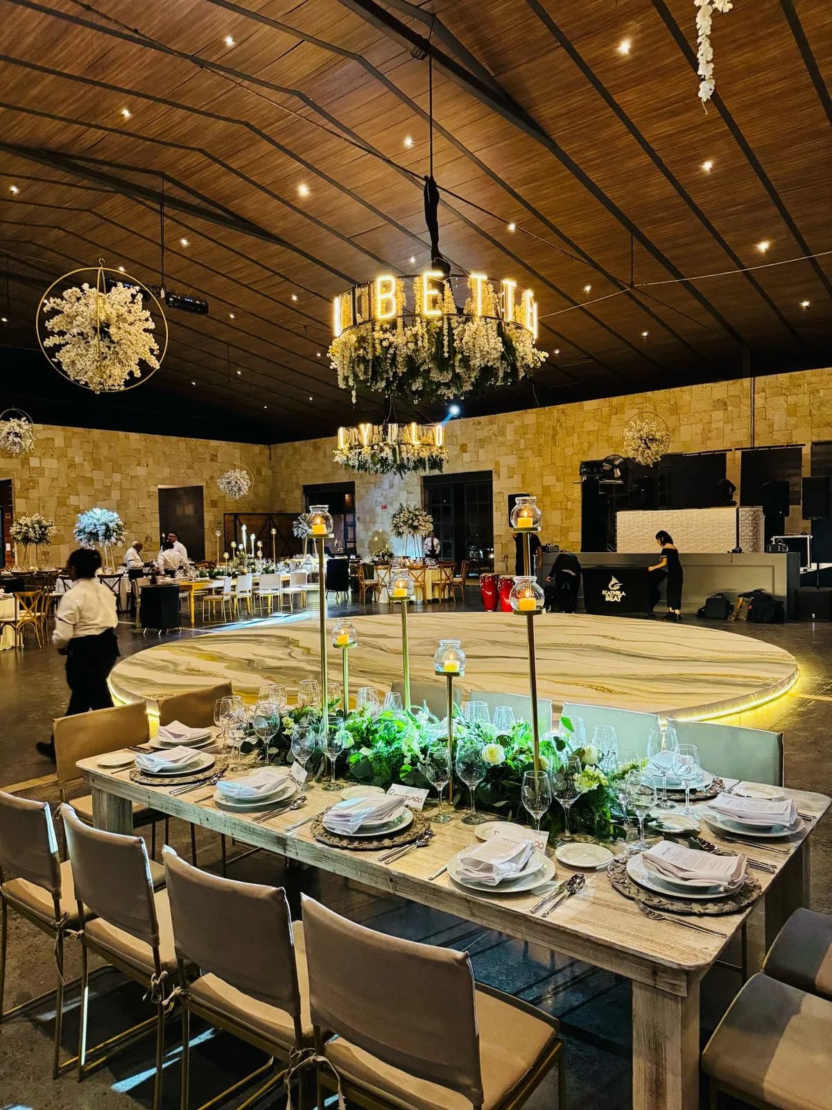 Banquete de boda junto a una pista redonda iluminada bajo candiles